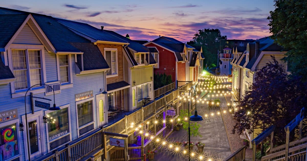 A picturesque street lined with colorful houses and illuminated by string lights at sunset. A picturesque street lined with colorful houses and illuminated by string lights at sunset.