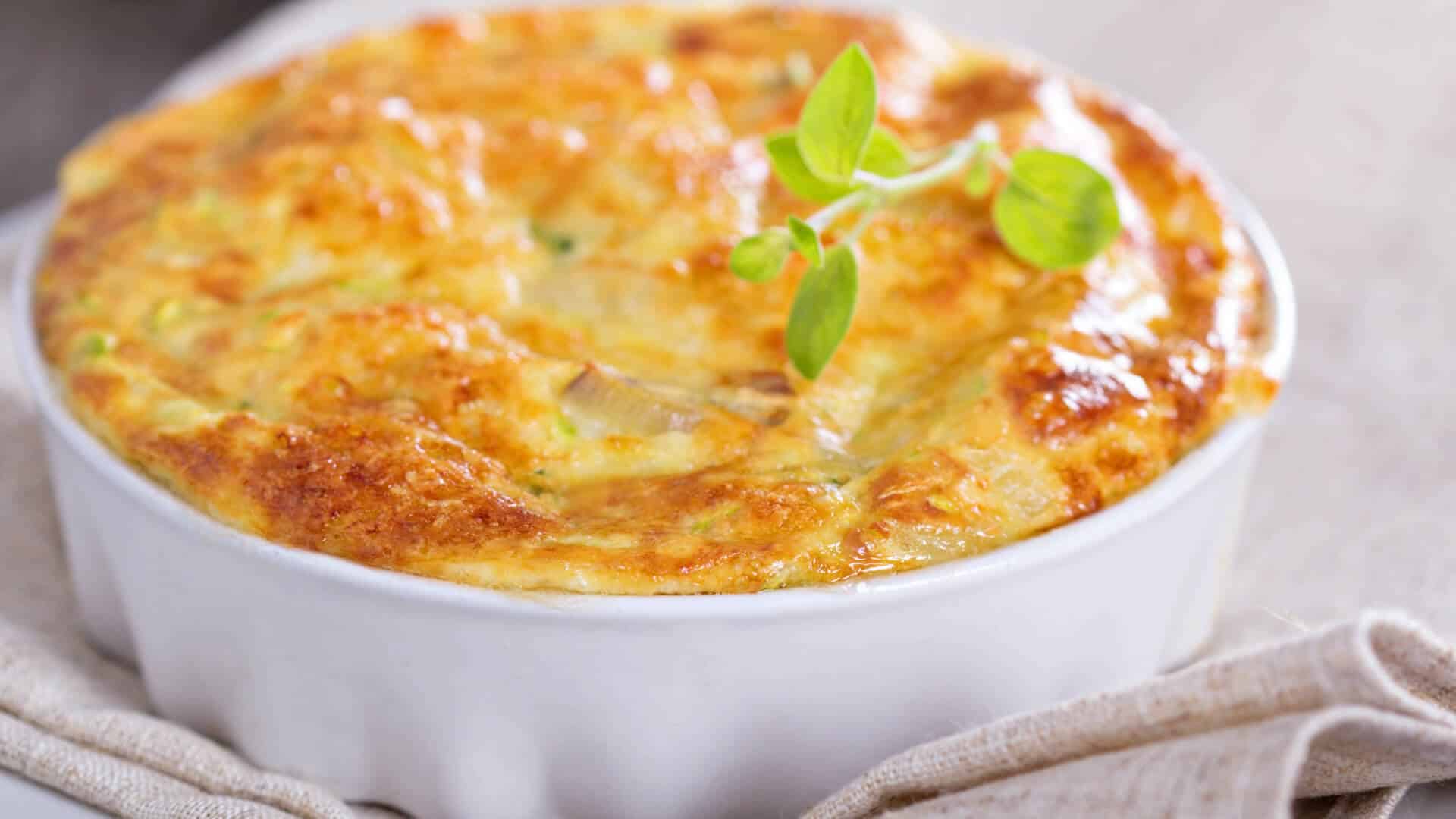 A golden-brown baked dish garnished with a sprig of green herb.